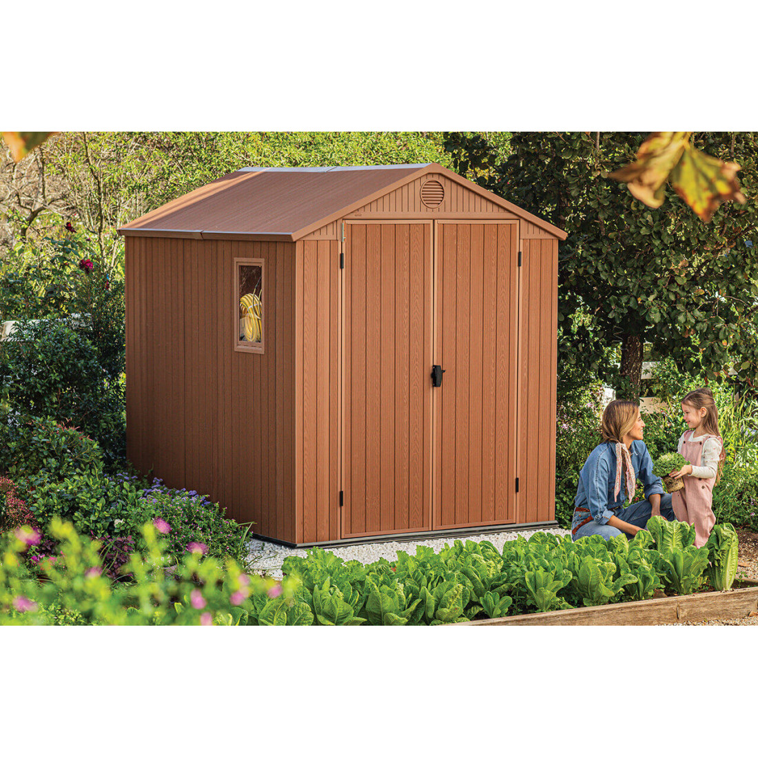 Aranżacja narzędziowni w ogrodzie, a obok niej kobieta z córką