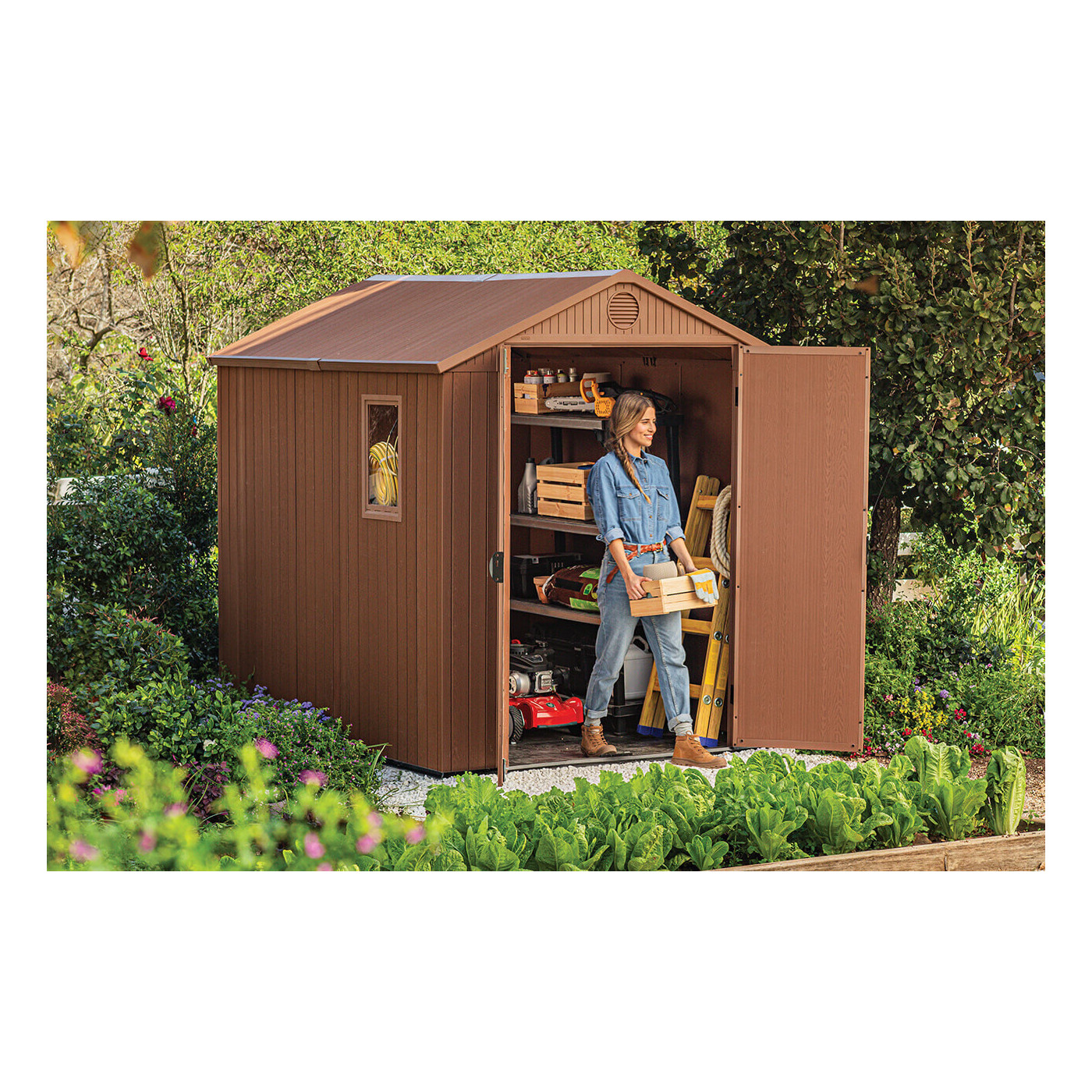 Widok na kobietę wychodzącą z szopy narzędziowej ze skrzynką