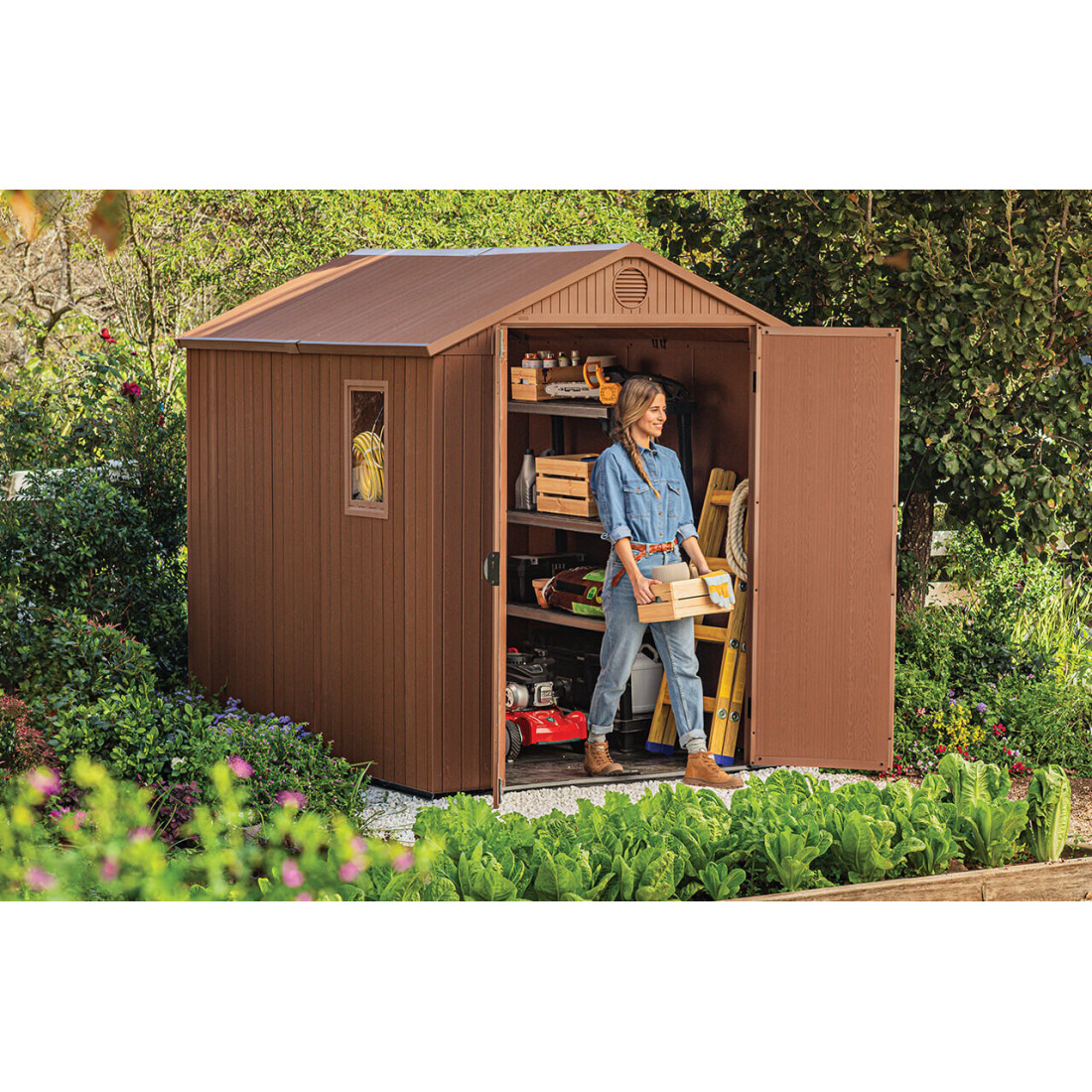 Widok na kobietę wychodzącą z szopy narzędziowej ze skrzynką