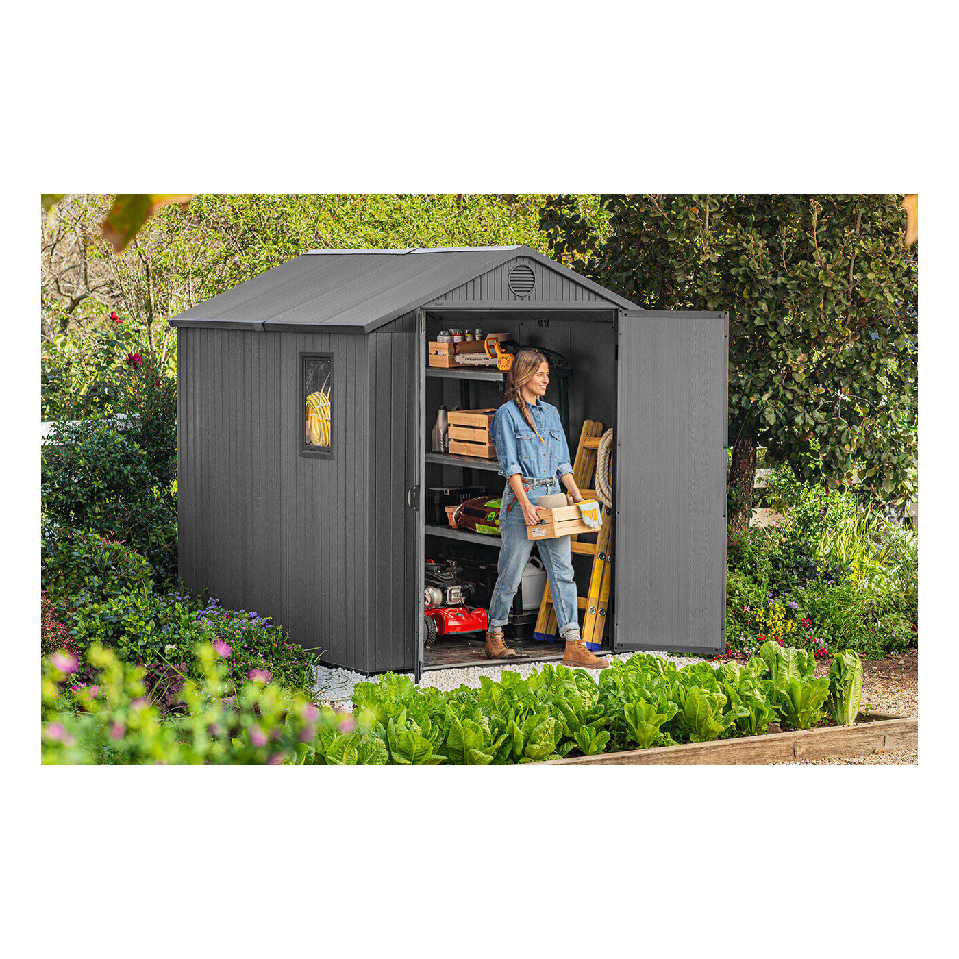 Widok na kobietę wychodzącą z szopy narzędziowej ze skrzynką