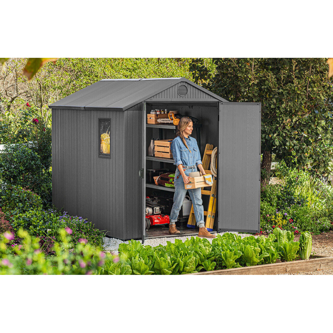 Widok na kobietę wychodzącą z szopy narzędziowej ze skrzynką