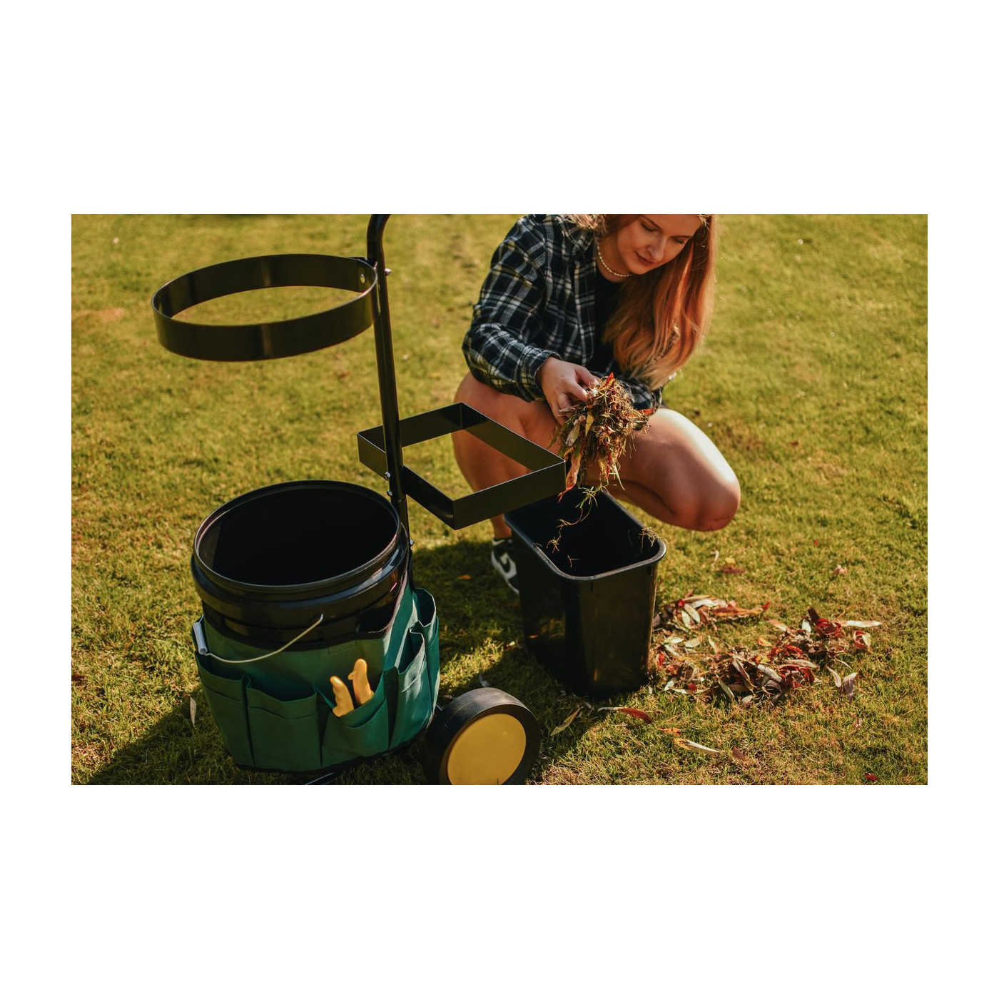 Kobieta pracująca w ogrodzie przy pomocy pojemnika z zestawu z wózkiem ogrodowym