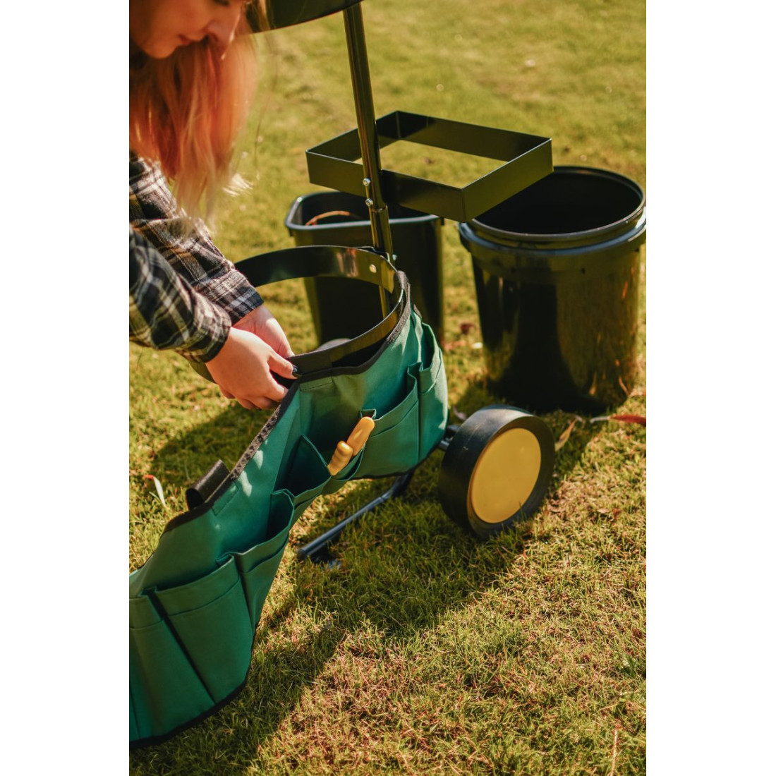 Kobieta zakładająca pas na narzędzia do wózka ogrodowego CULTIVO