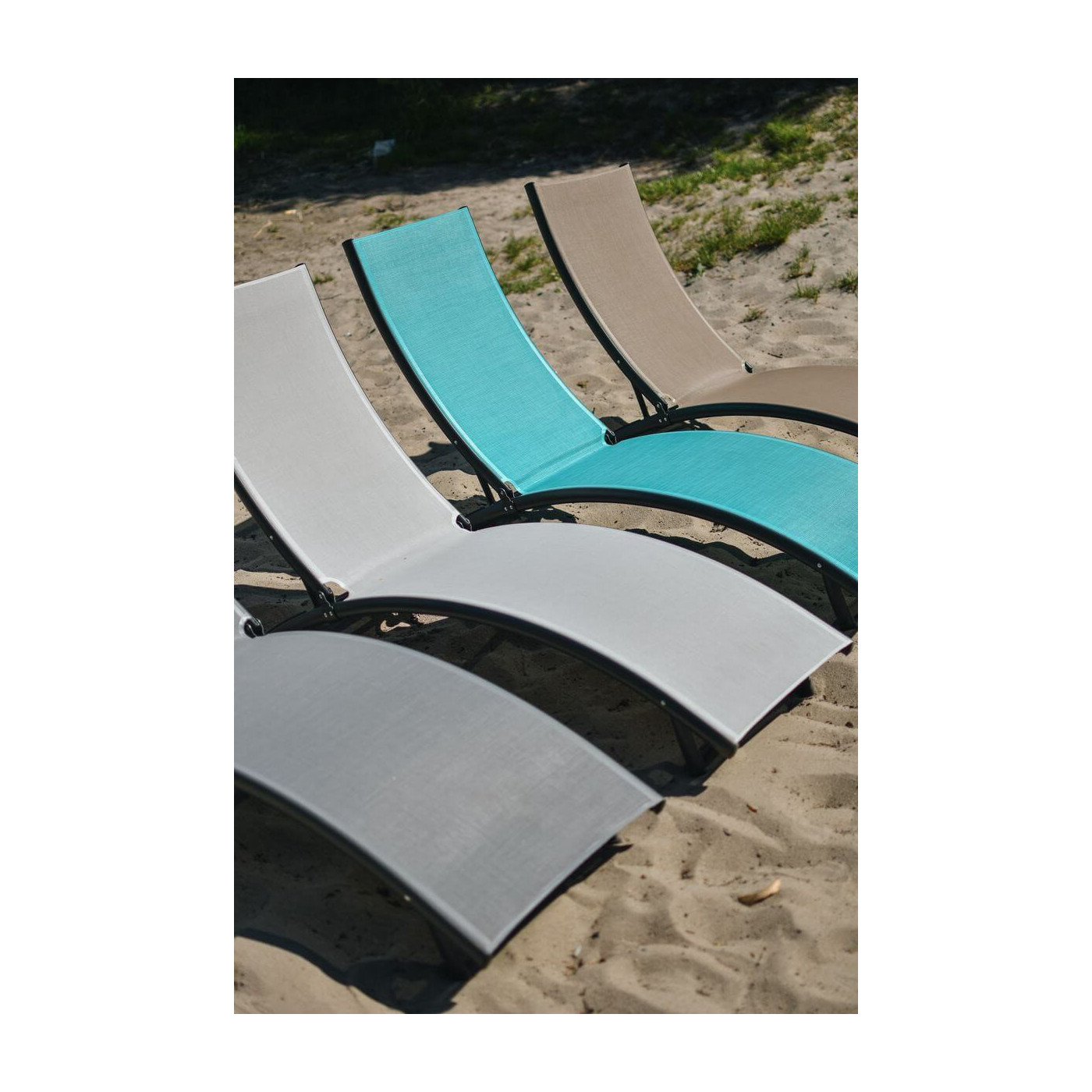 aranżacja czterech leżaków Star ustawionych obok siebie na piasku 