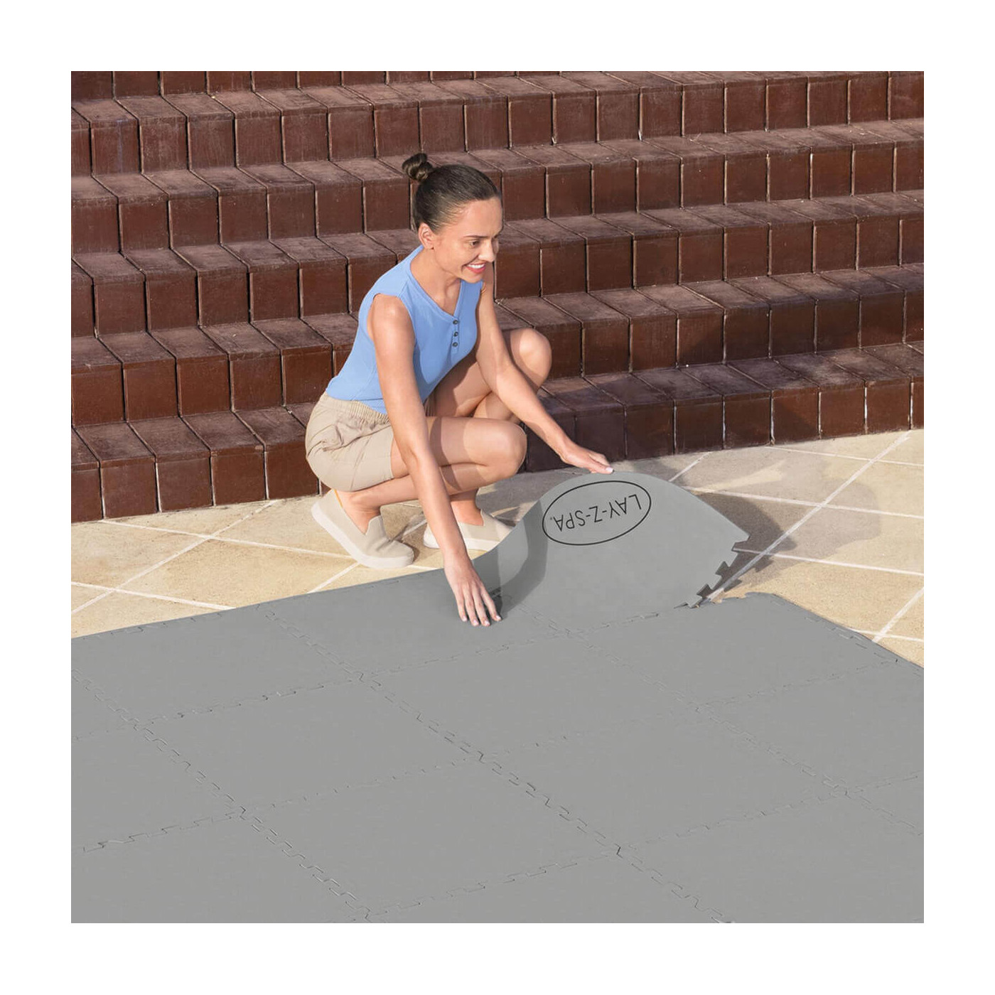 Kobieta układająca matę z wytrzymałego materiału polietylenowego zapewniającego ochronę pod spa