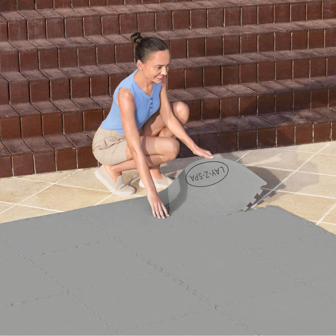 Kobieta układająca matę z wytrzymałego materiału polietylenowego zapewniającego ochronę pod spa