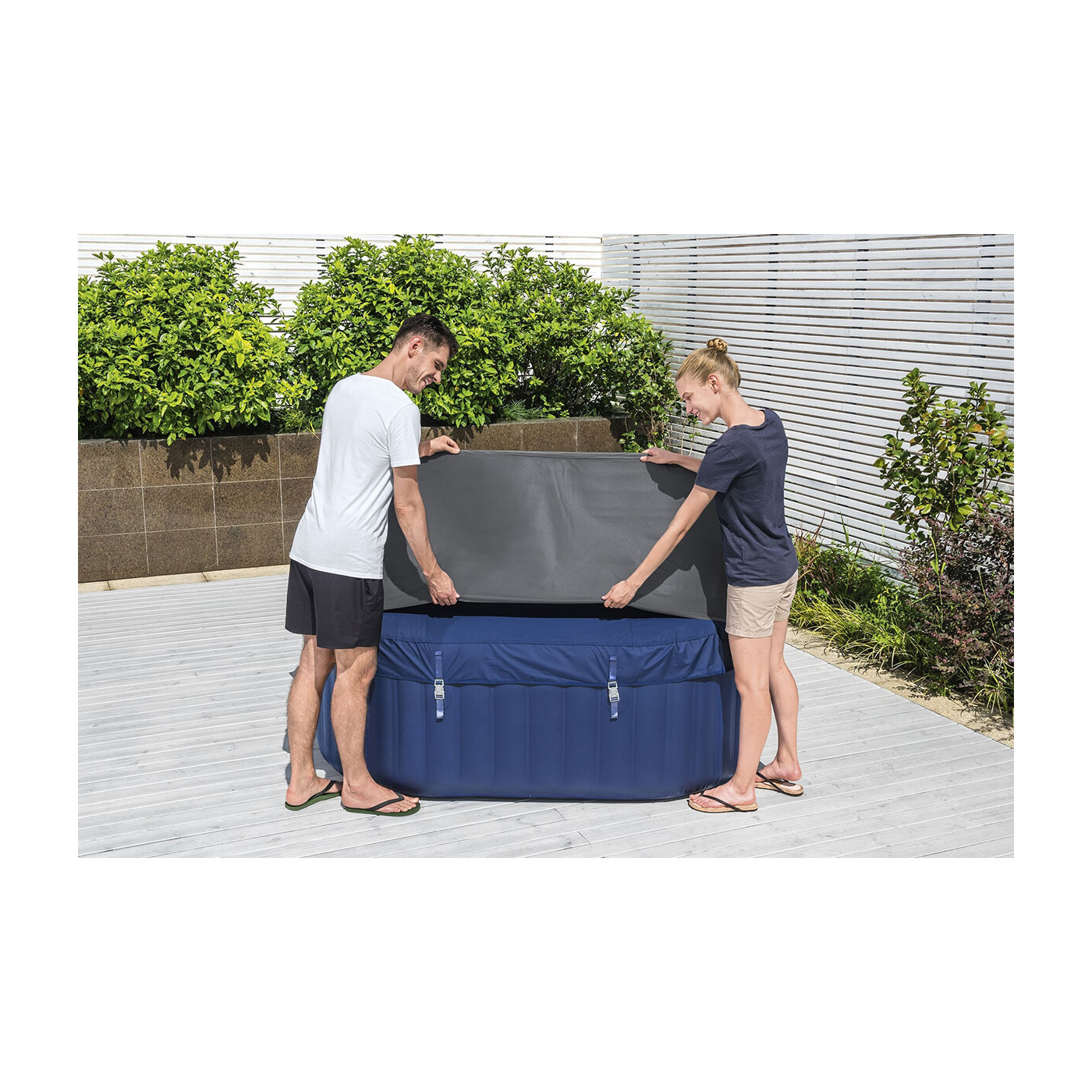 Widok na kobietę i mężczyznę, którzy nakładają pokrywę termiczną na jacuzzi