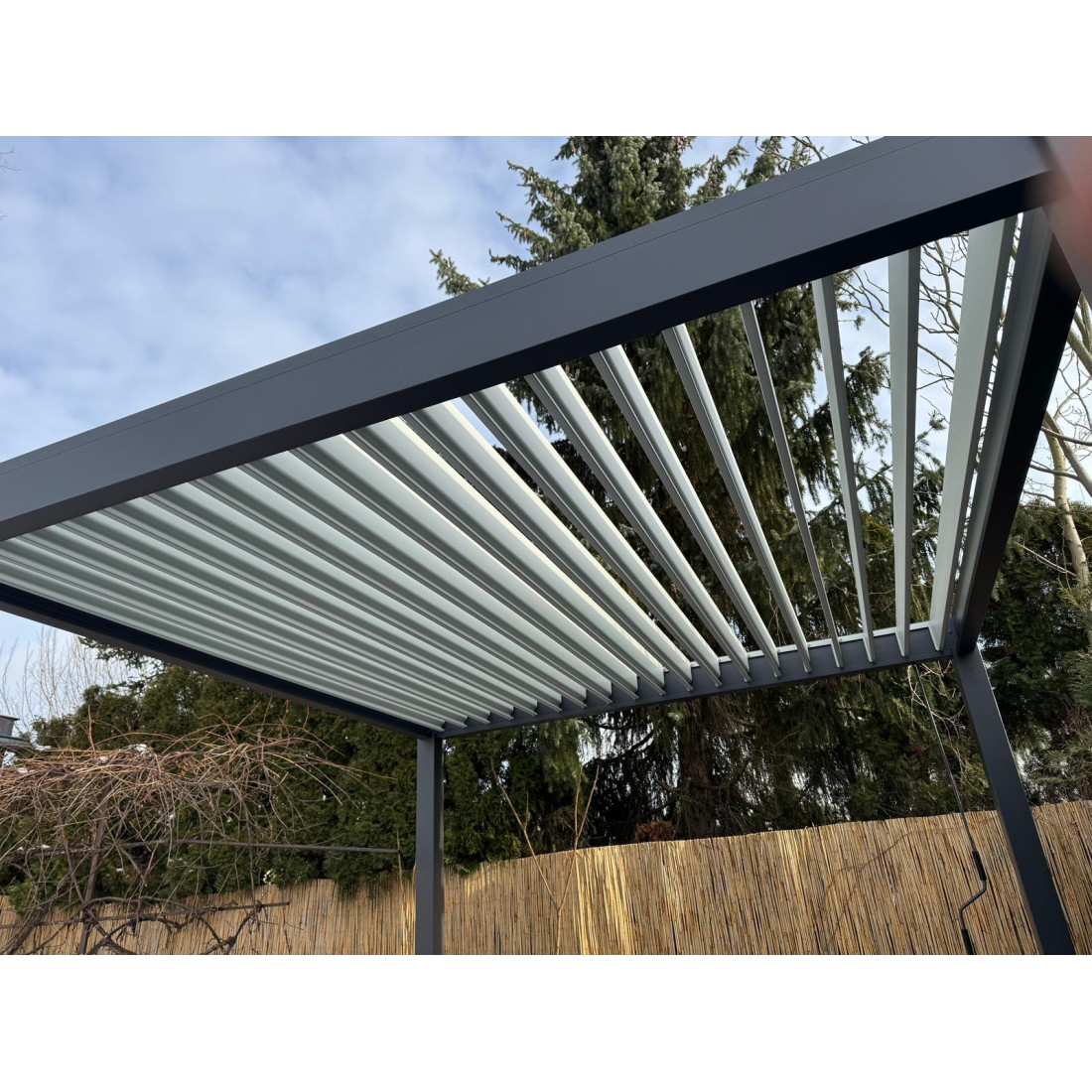 Aranżacja pergoli ogrodowej na taras Elegance w rozmiarze 3x4 w kolorze antracytowym z jasnoszarymi lamelami