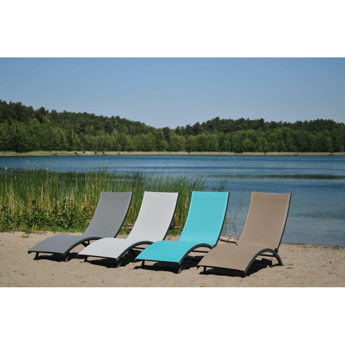 cztery leżaki w różnych kolorach na piasku na tle jeziora