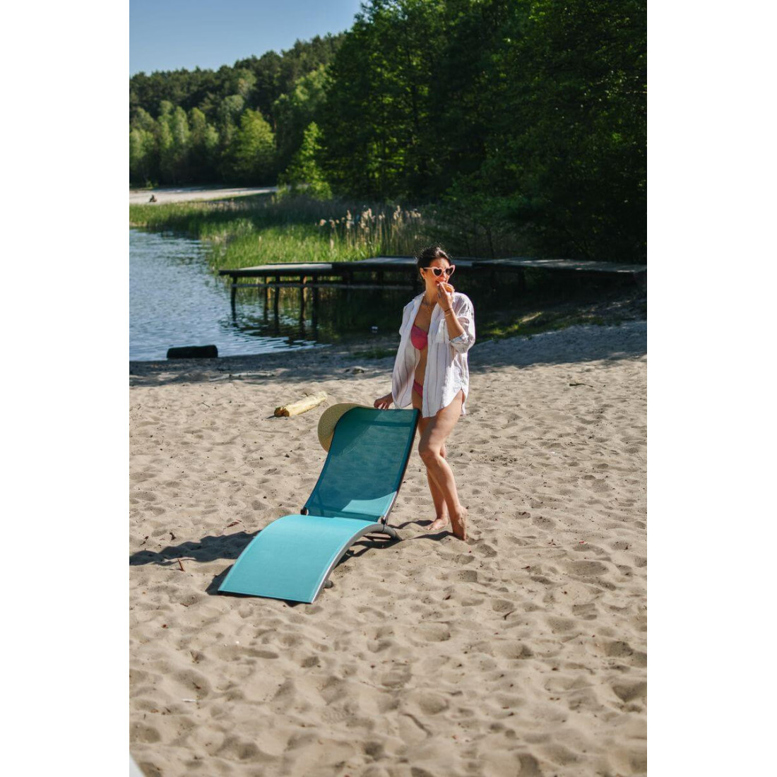 Kobieta stojąca za leżakiem star w kolorze niebieskim