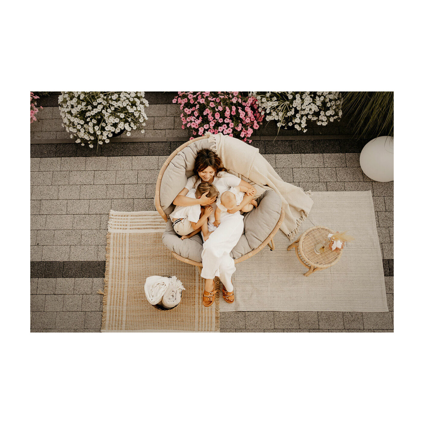 Kobieta przytulająca swoje dzieci w fotelu bujanym