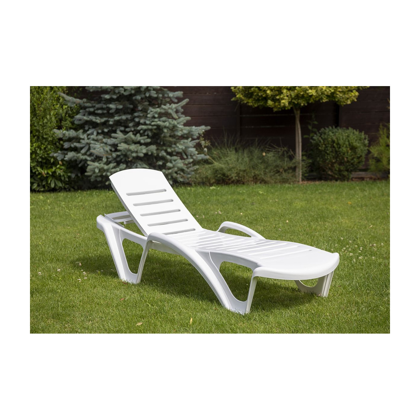 Leżak monoblock biały na tle ogrodu
