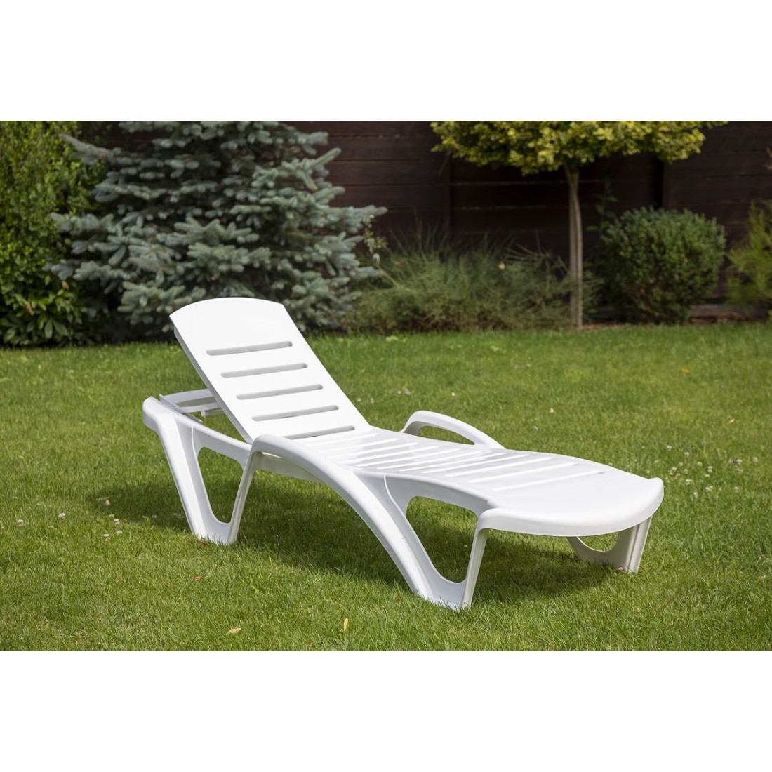 Leżak monoblock biały na tle ogrodu
