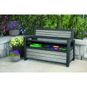 Otwarta skrzynia ogrodowa w ławce ogrodowej, w której znajdują się akcesoria ogrodowe