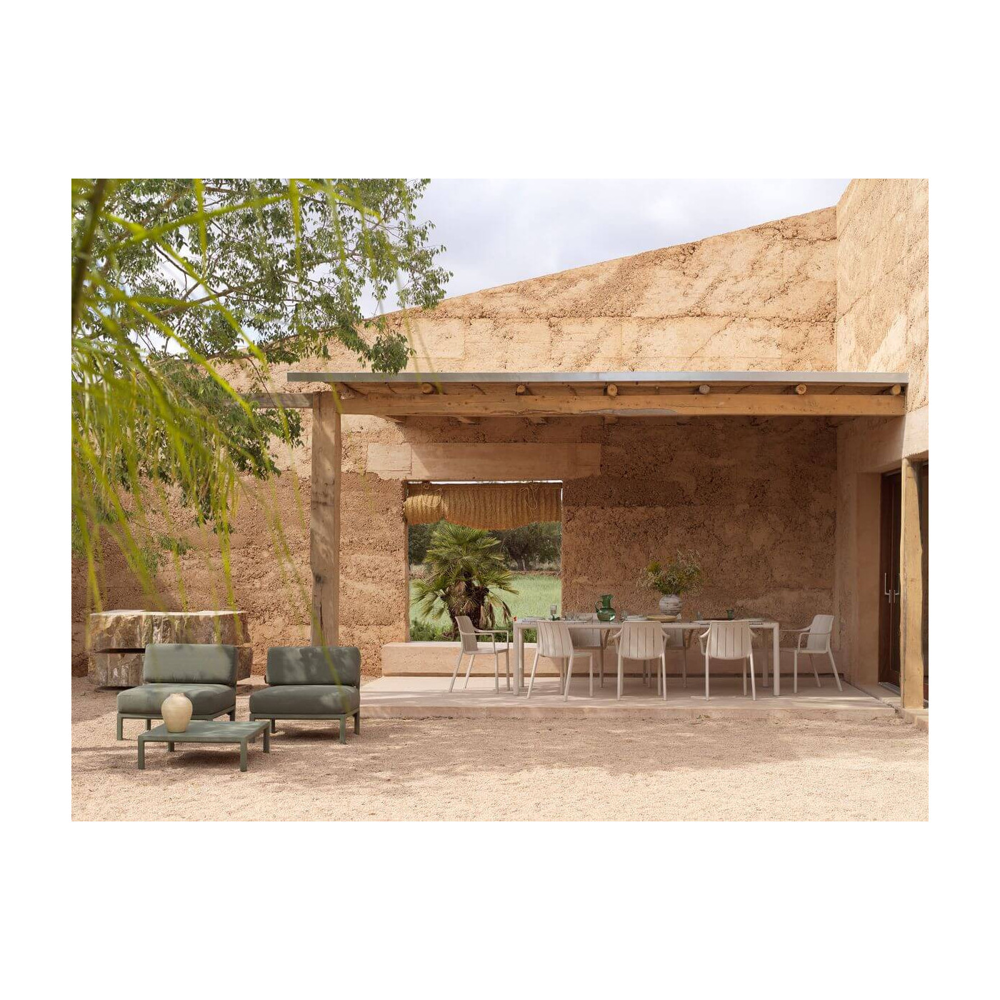 Krzesła TIBERINA Corda Nardi ustawione przy stole na rustykalnym tarasie z widokiem na ogród