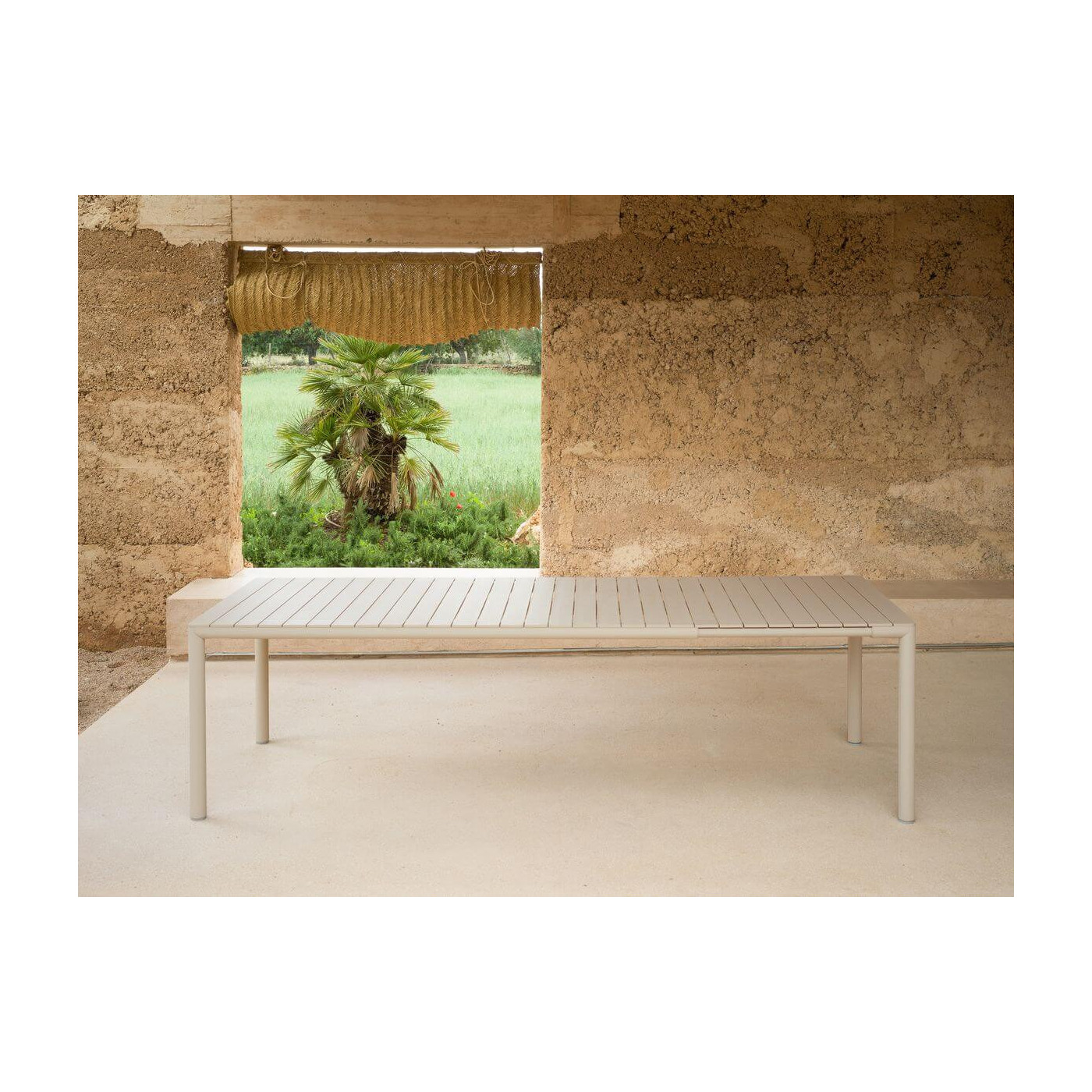 Rozłożony stół ogrodowy TEVERE 210 Corda w aranżacji z surową ścianą