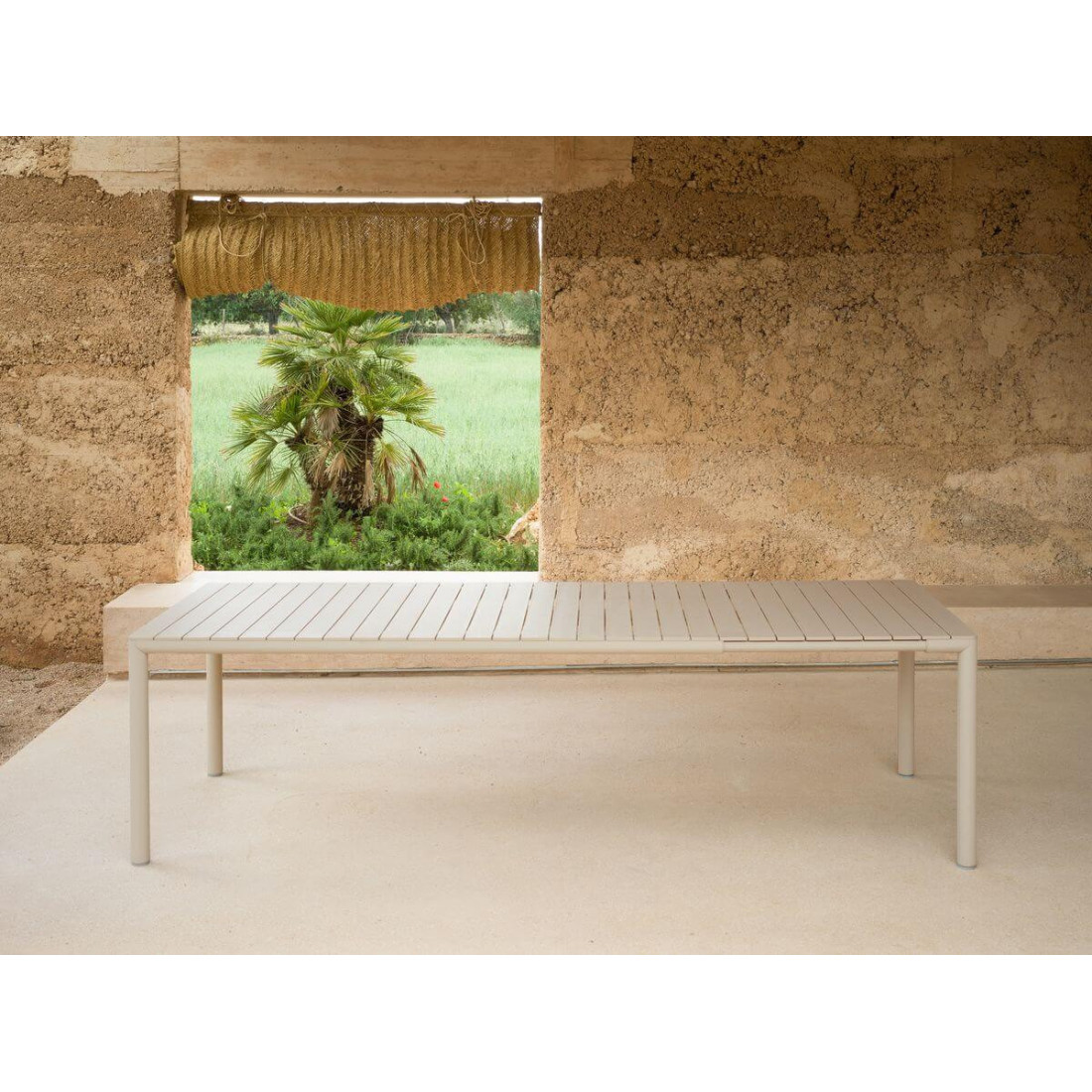 Rozłożony stół ogrodowy TEVERE 210 Corda w aranżacji z surową ścianą