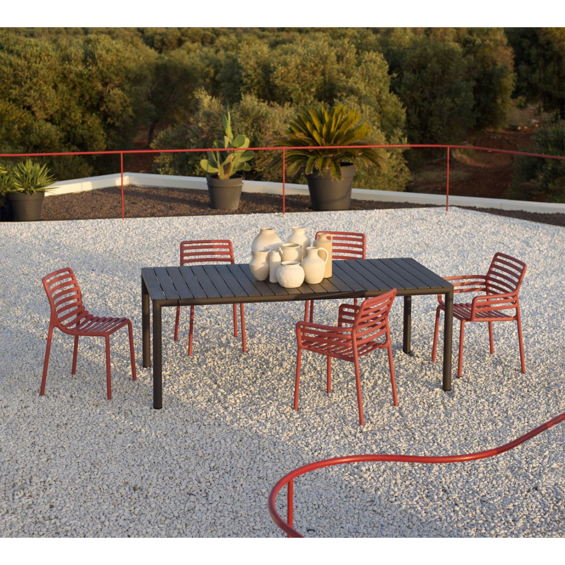 Stół ogrodowy Tevere 210 w kolorze antracytowym z czerwonymi krzesłami Nardi na tarasie